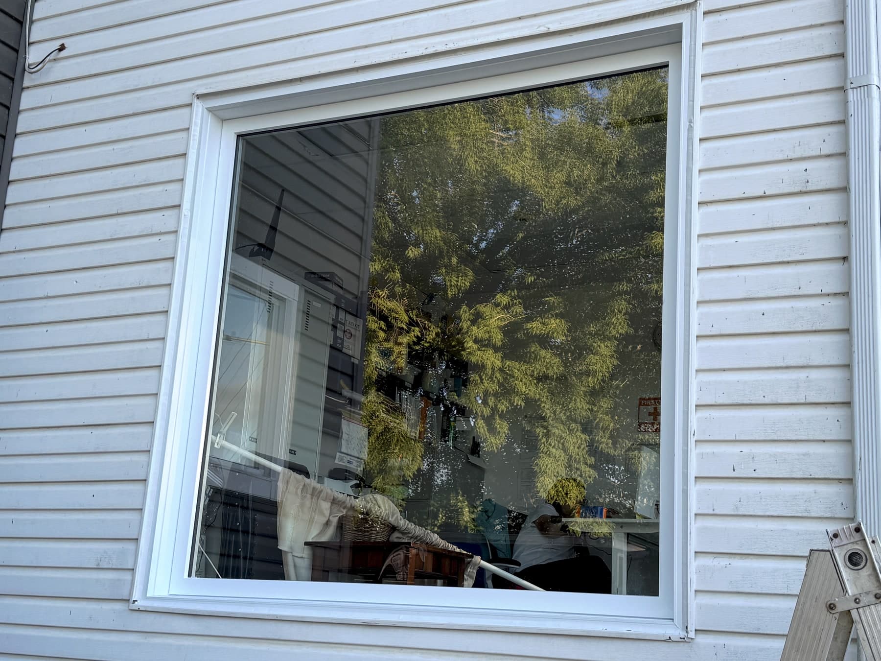 Fenêtre blanche sur une façade à clin, vue de l’extérieur