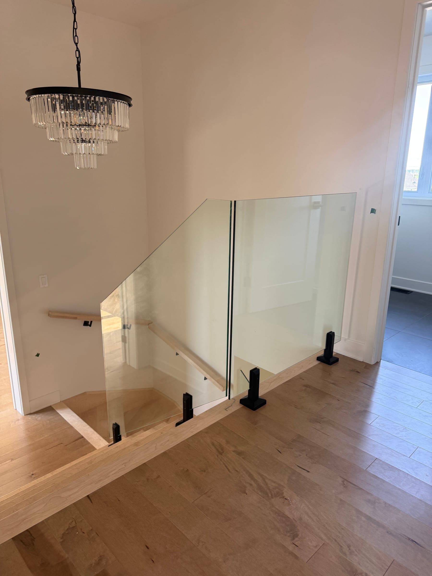 Garde-corps de mezzanine en verre sous un lustre à pampilles